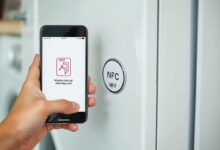 هاتف يقرأ ملصقات NFC للأجهزة على غسالة
